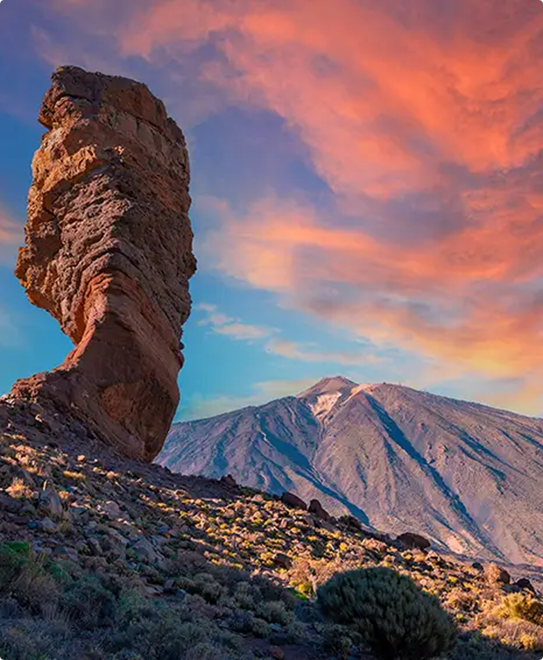 Teide National Park sunset: dramatic rock formation against volcanic mountain.
