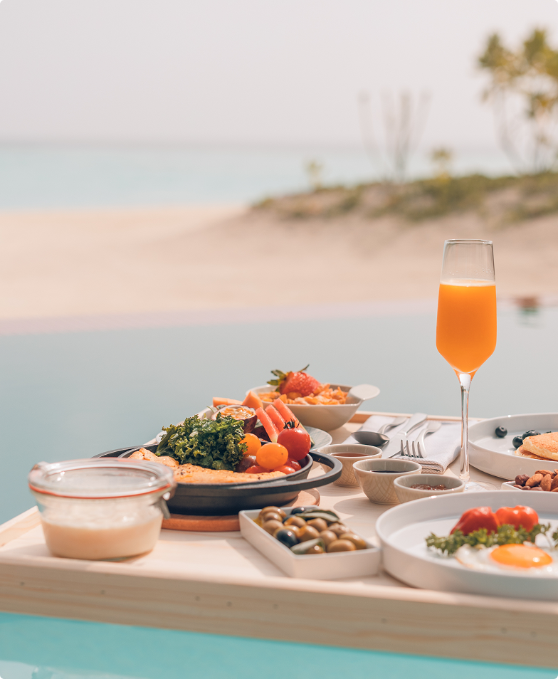 Luxurious beachside breakfast spread with fresh fruit, pastries, and juice.