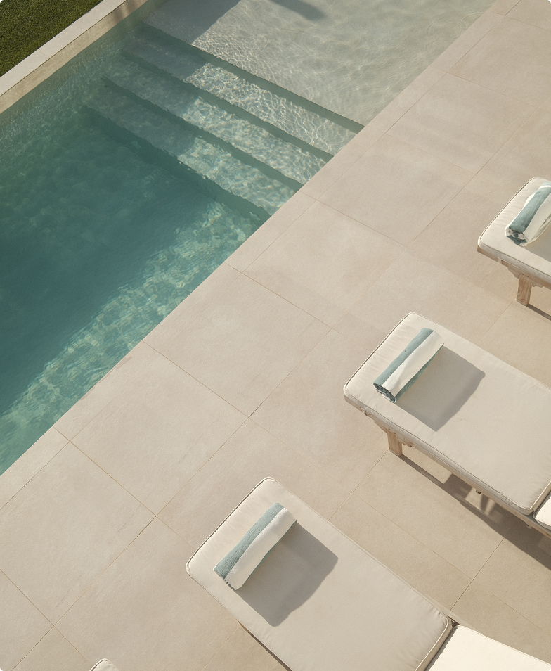 Tranquil poolside scene with lounge chairs and towels.